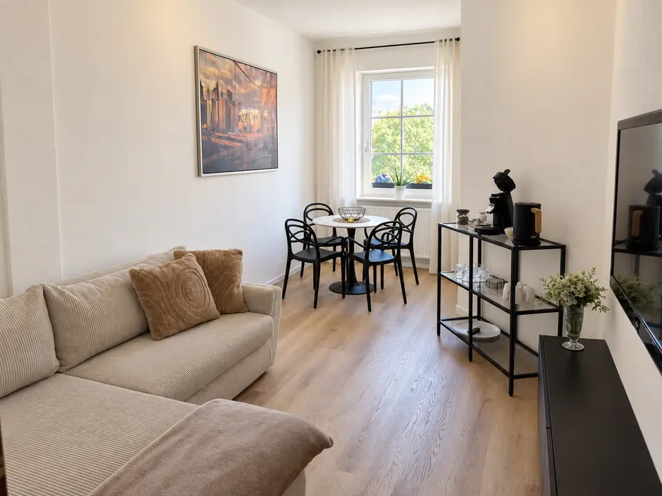 Heller Wohn- und Essbereich mit Sofa und rundem Esstisch
